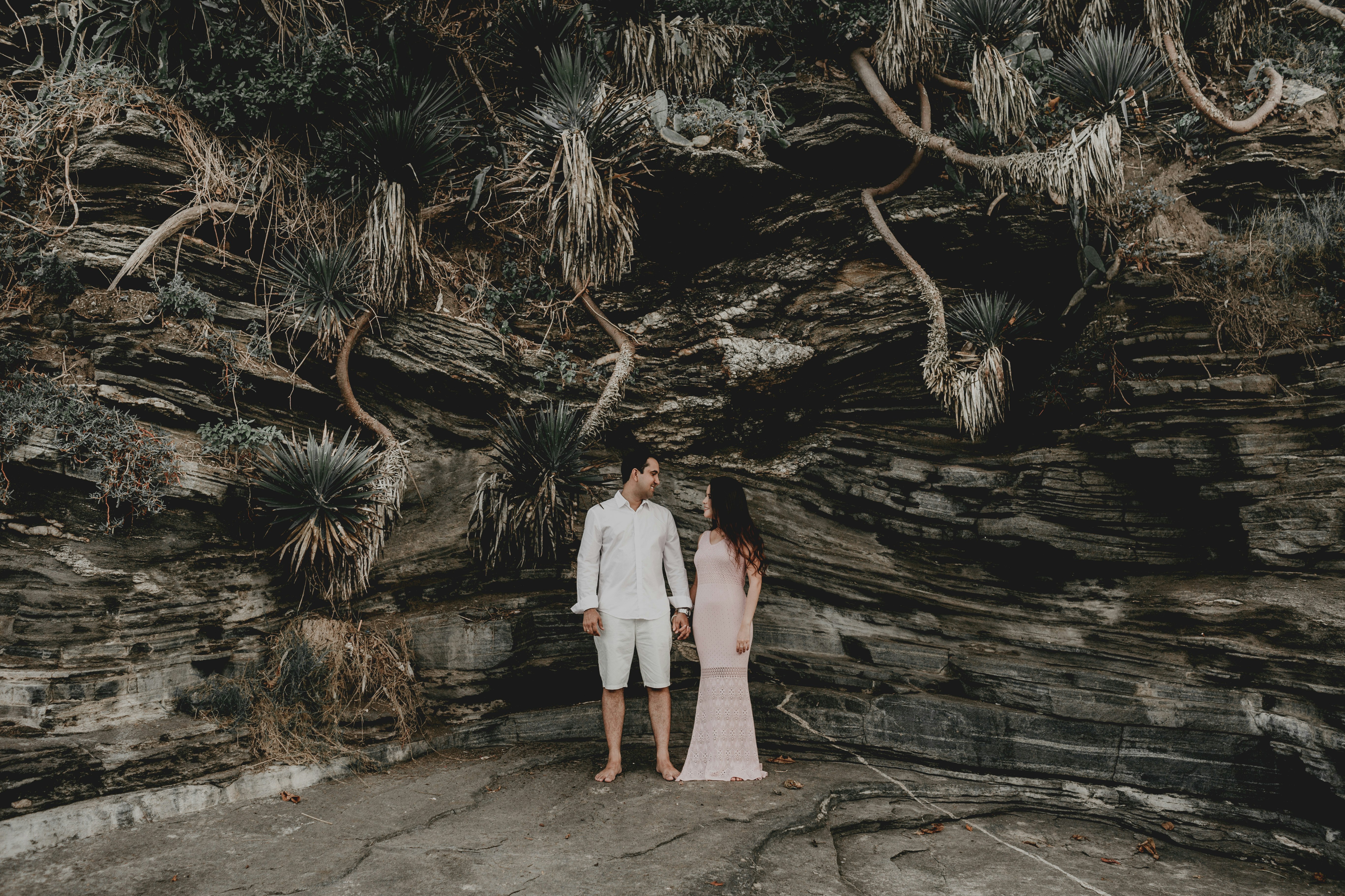 man and woman standing on brown wooden pathway